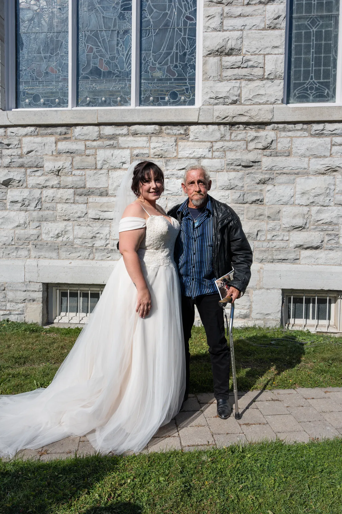 The bride posing with a male guest outside the church at Kody and Jaz’s wedding.
