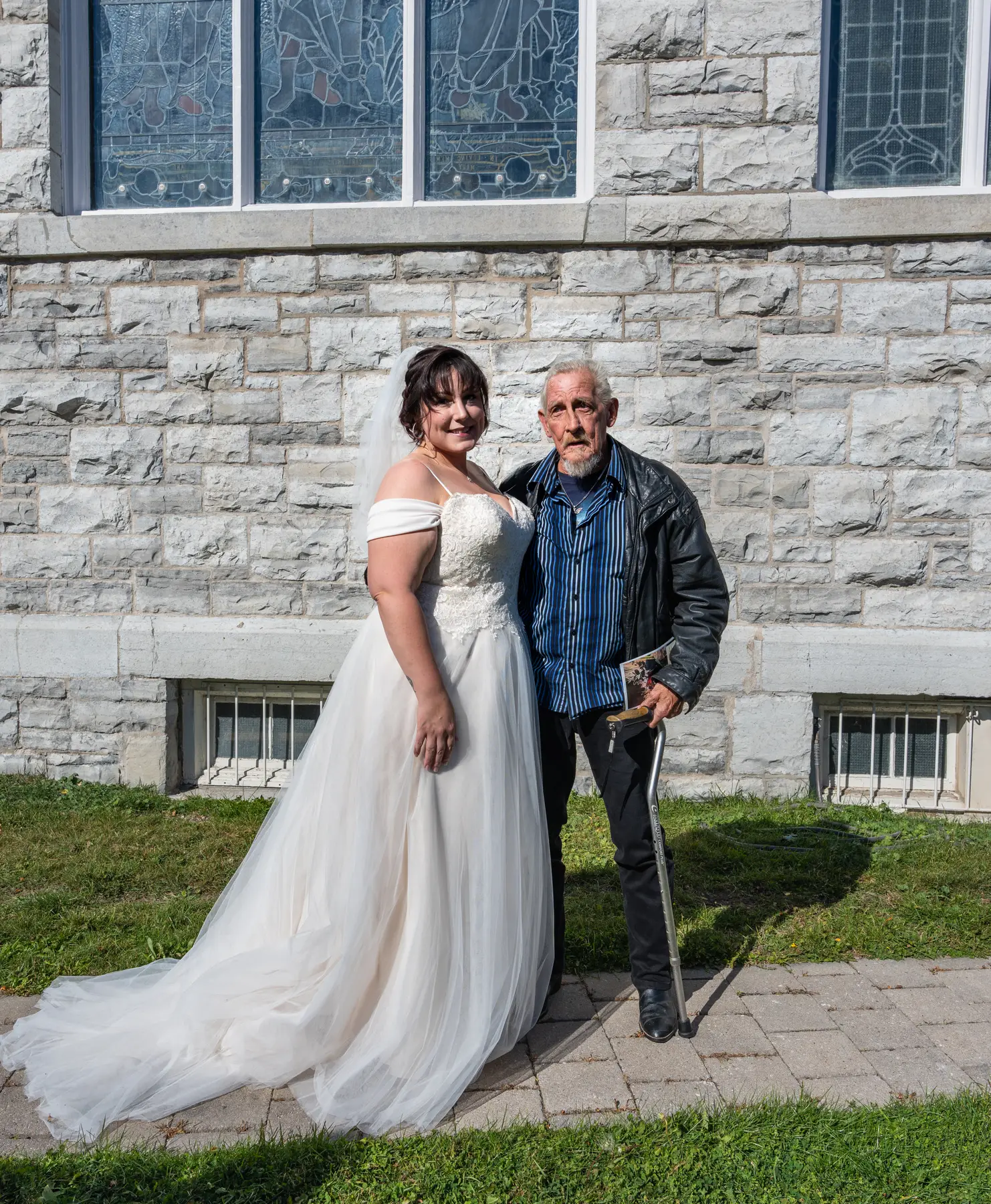 The bride posing with a male guest outside the church at Kody and Jaz’s wedding.