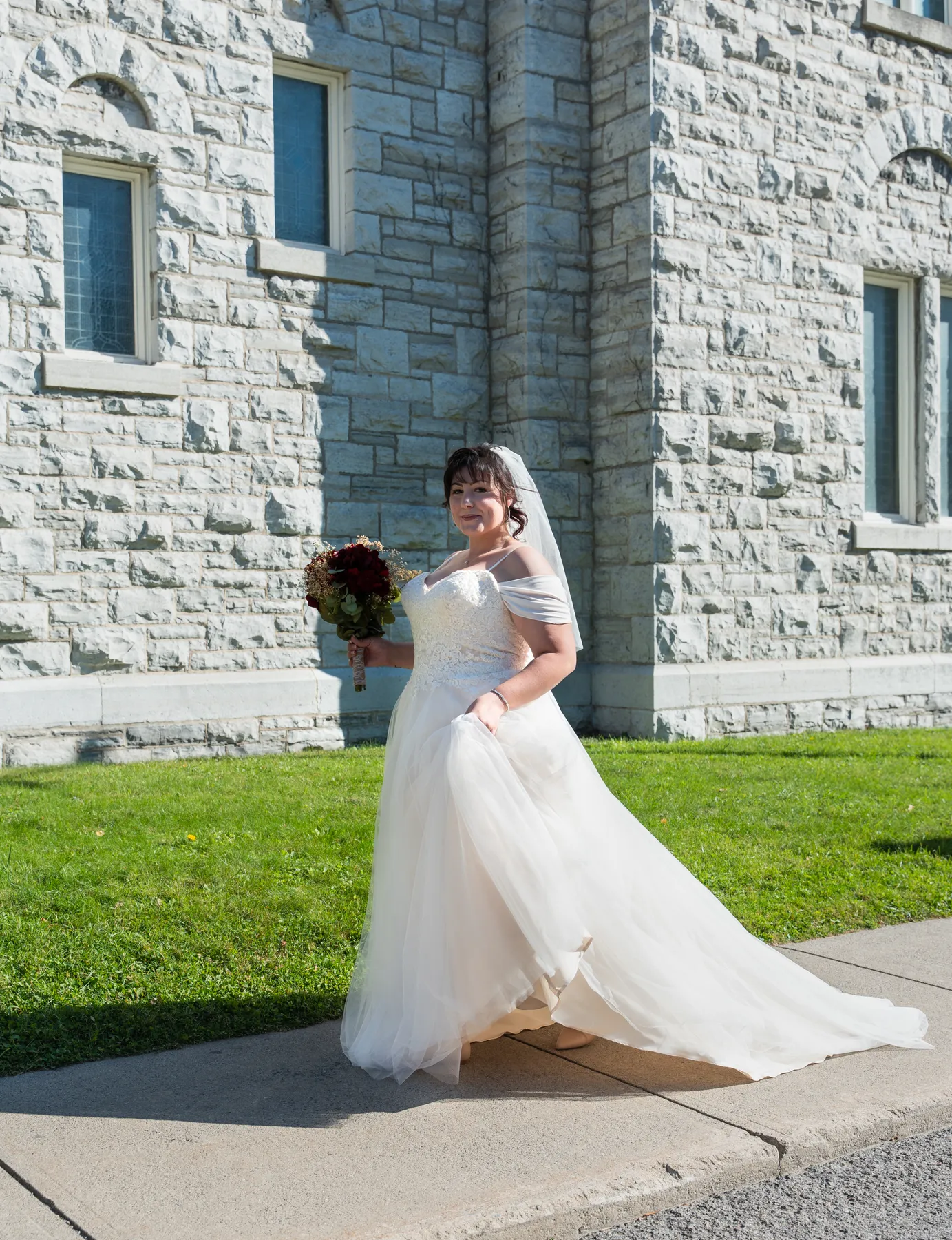The bride posing beside the church at Kody and Jaz’s wedding.
