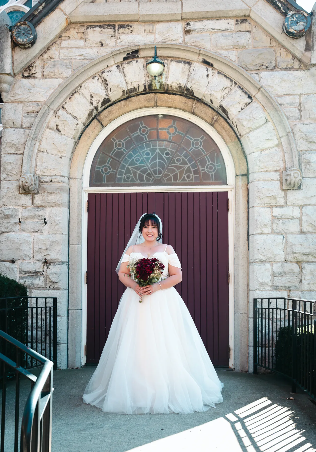 The bride posing beside the church at Kody and Jaz’s wedding.
