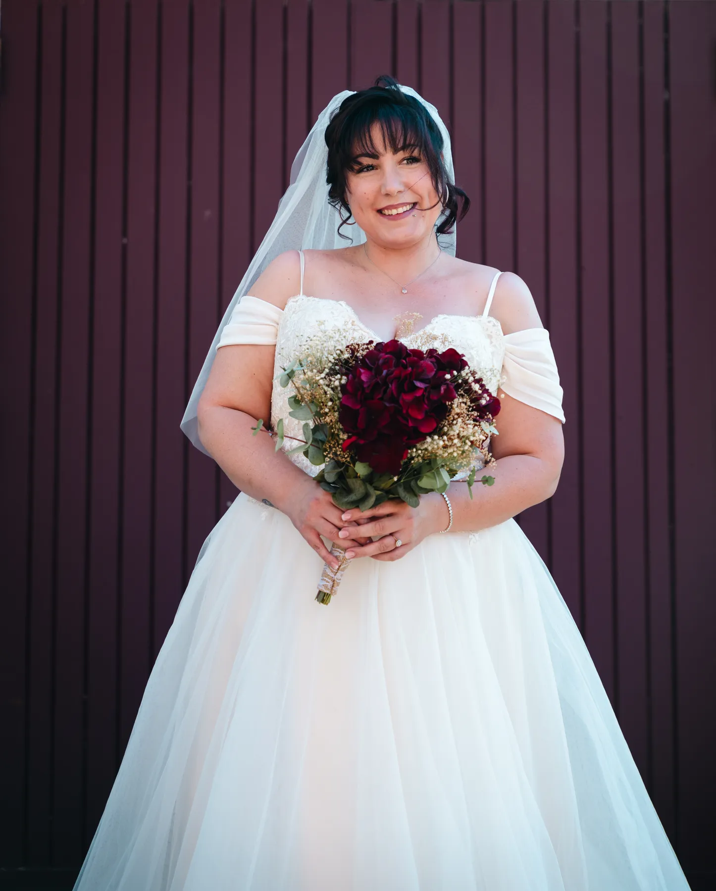 The bride posing at the red church door at Kody and Jaz’s wedding.