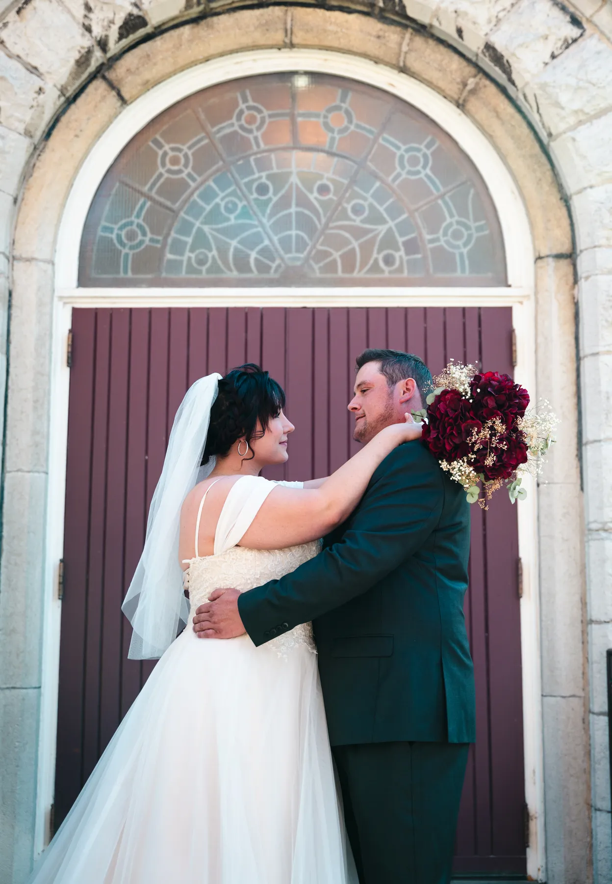 The couple embracing at the church door at Kody and Jaz’s wedding.