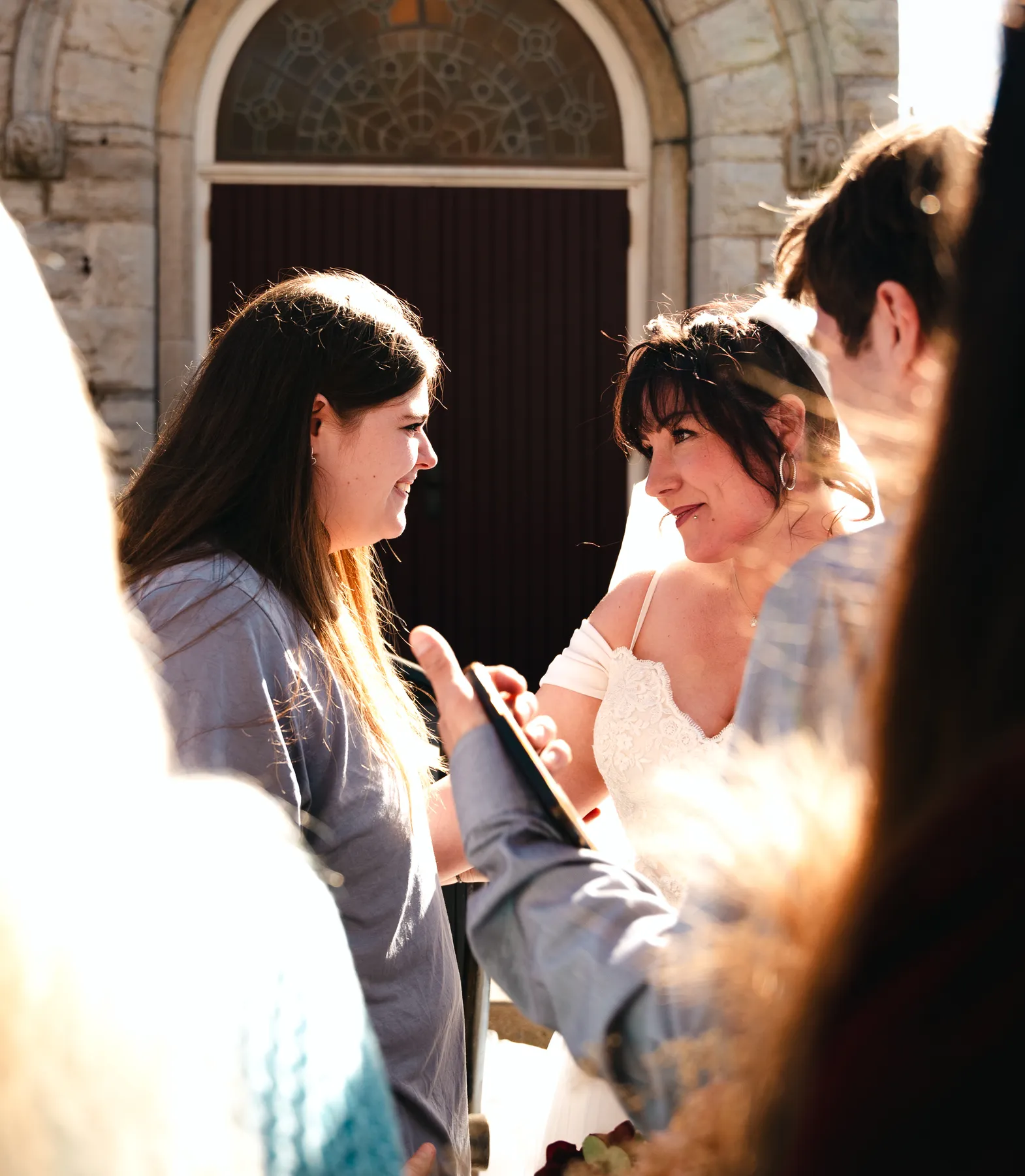 The bride greeting guests outdoors at Kody and Jaz’s wedding.