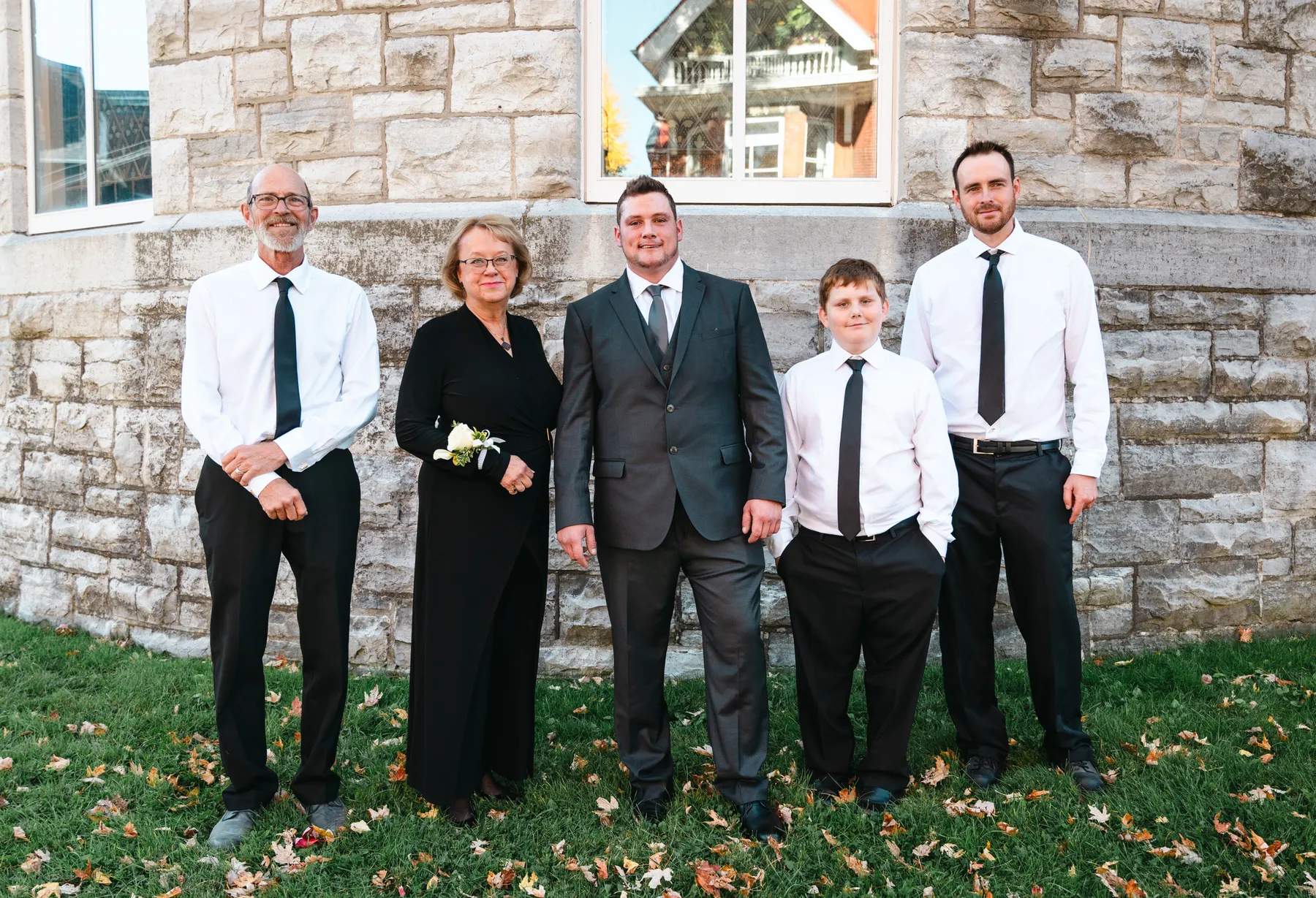 The groom posing with male guests outside the church at Kody and Jaz’s wedding.