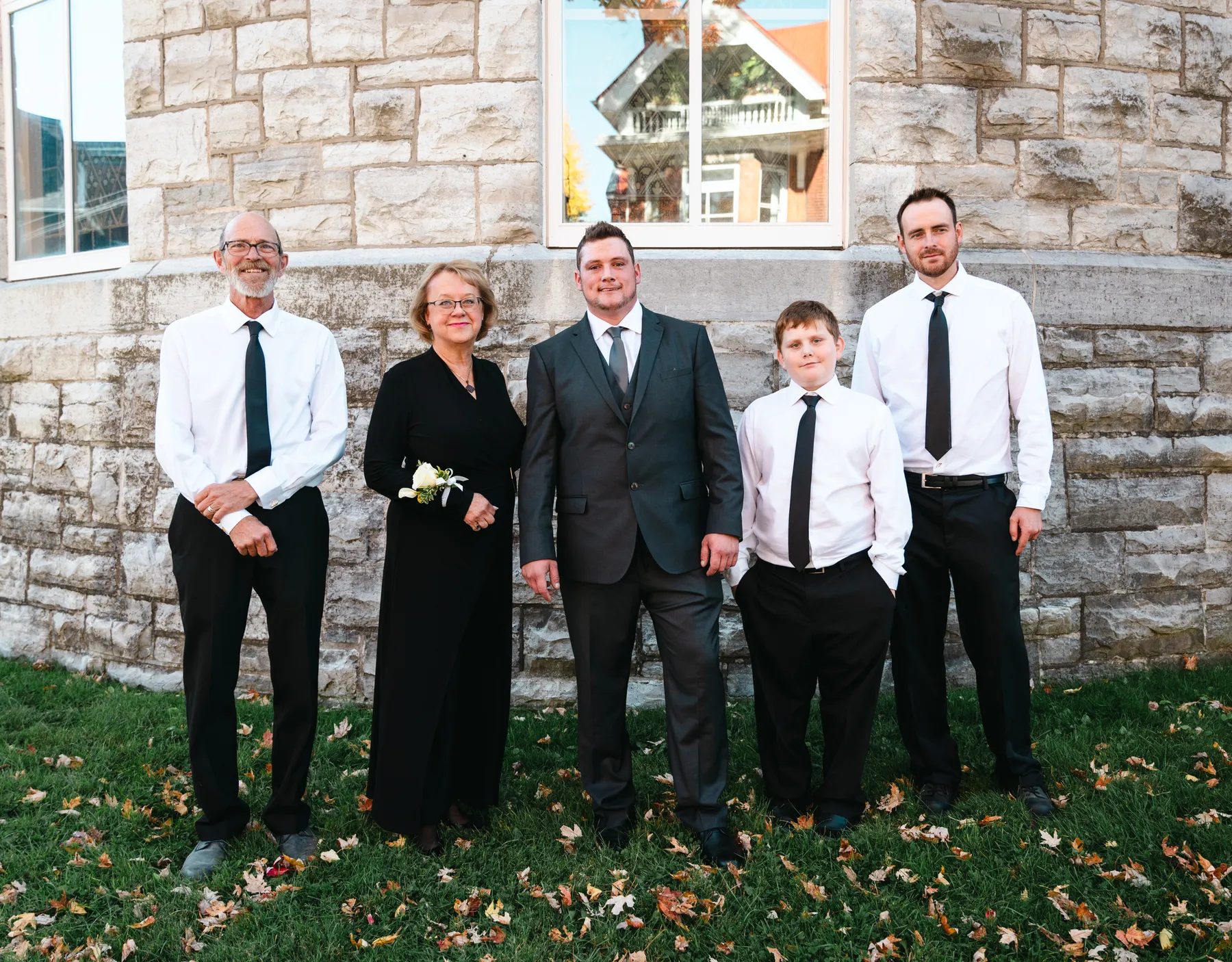 The groom posing with male guests outside the church at Kody and Jaz’s wedding.