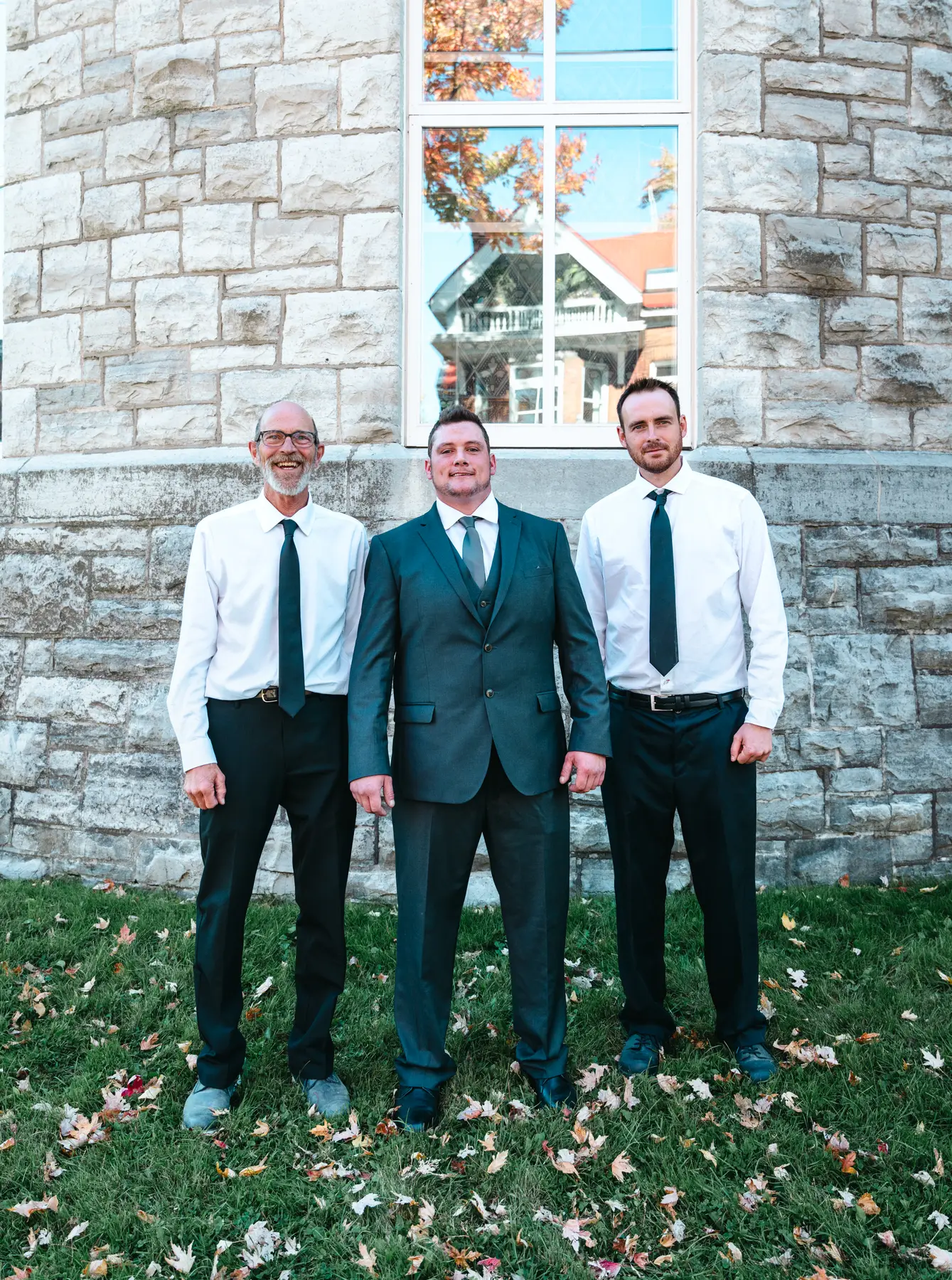 The groom posing with male guests outside the church at Kody and Jaz’s wedding.