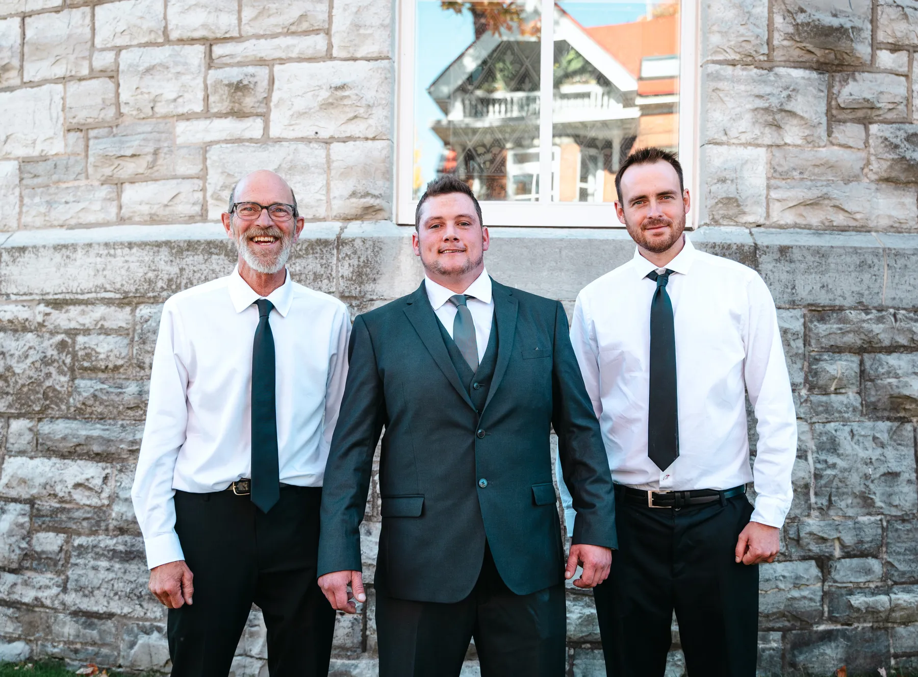 The groom posing with male guests outside the church at Kody and Jaz’s wedding.