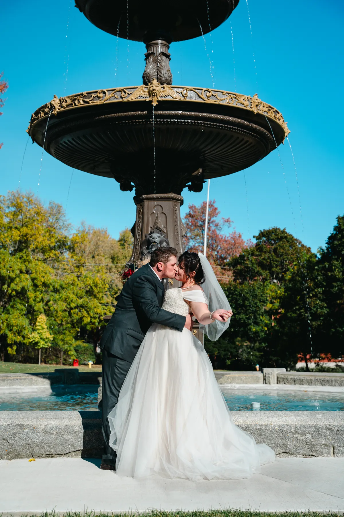The couple posing by a large fountain at Kody and Jaz’s wedding.