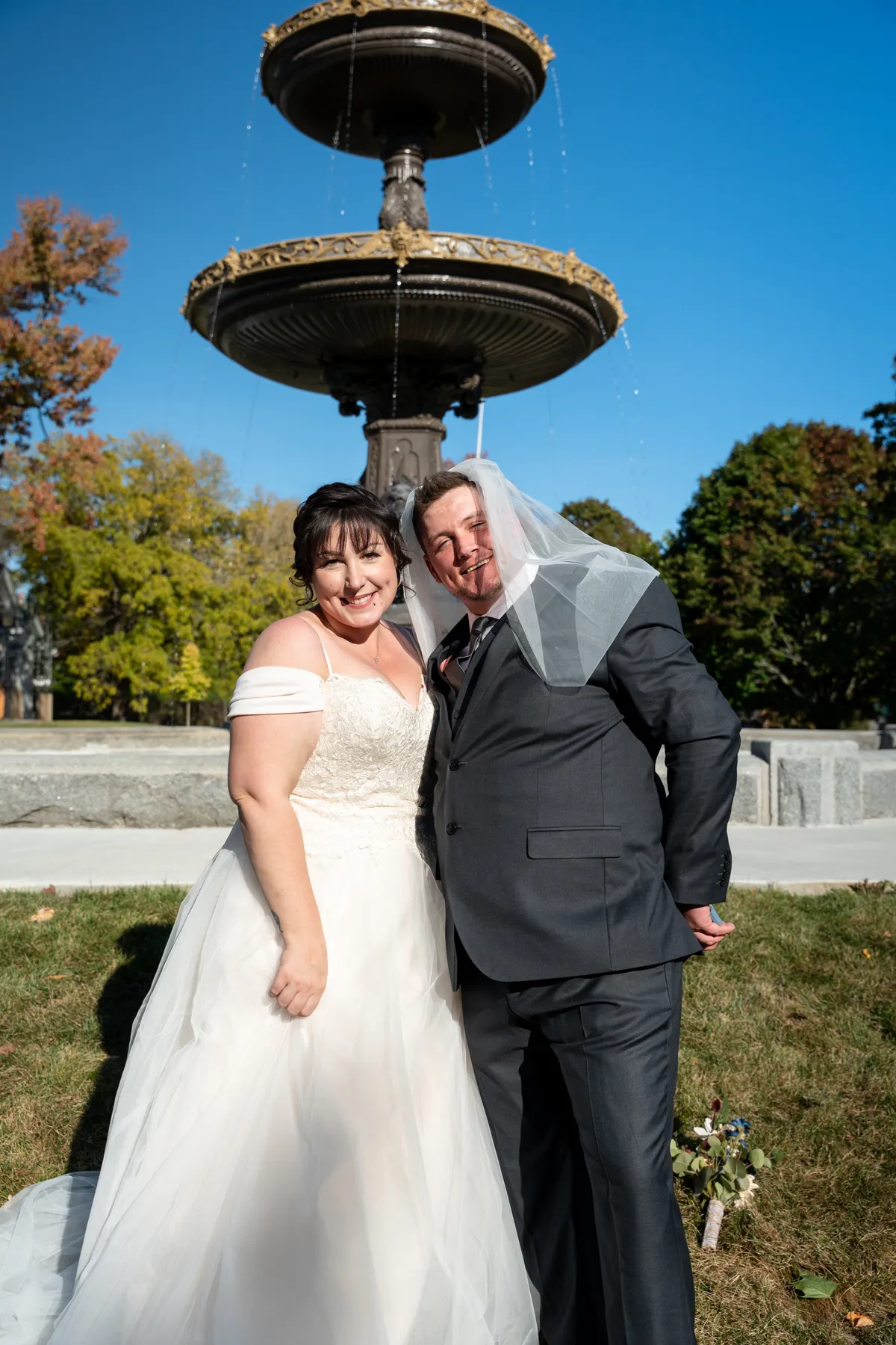 The couple sharing playful moments beside the fountain at Kody and Jaz’s wedding.
