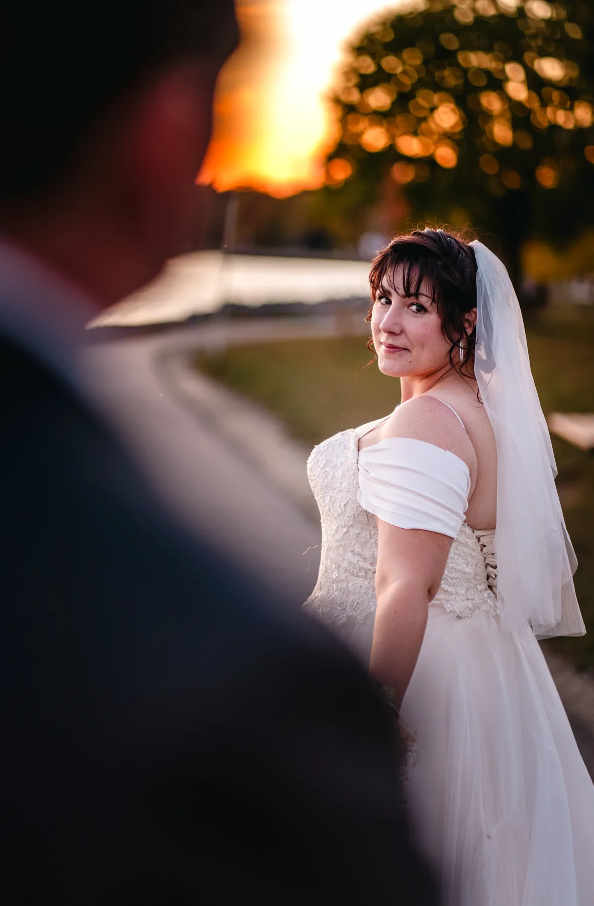 The bride posing by the water at sunset at Kody and Jaz’s wedding.