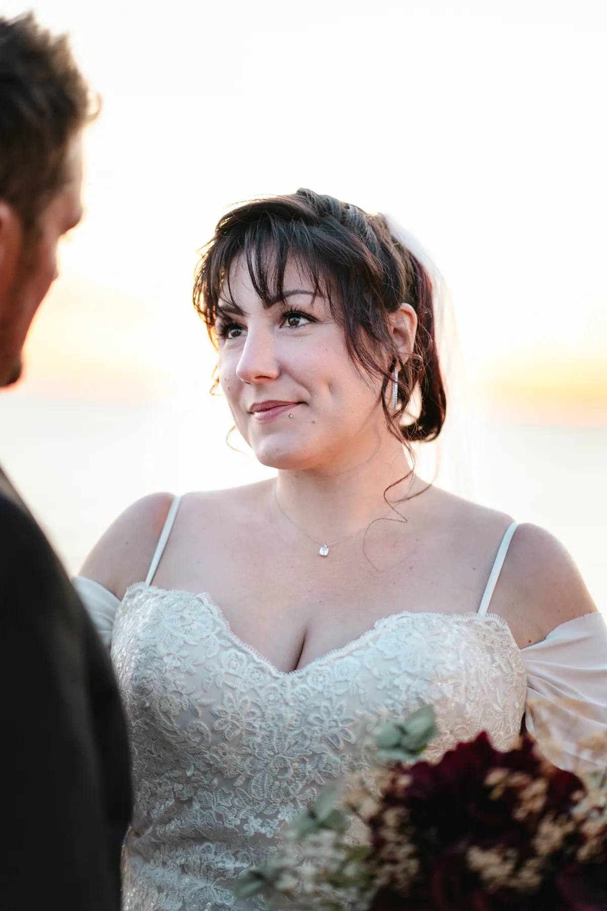 The couple posing by the water at sunset at Kody and Jaz’s wedding.