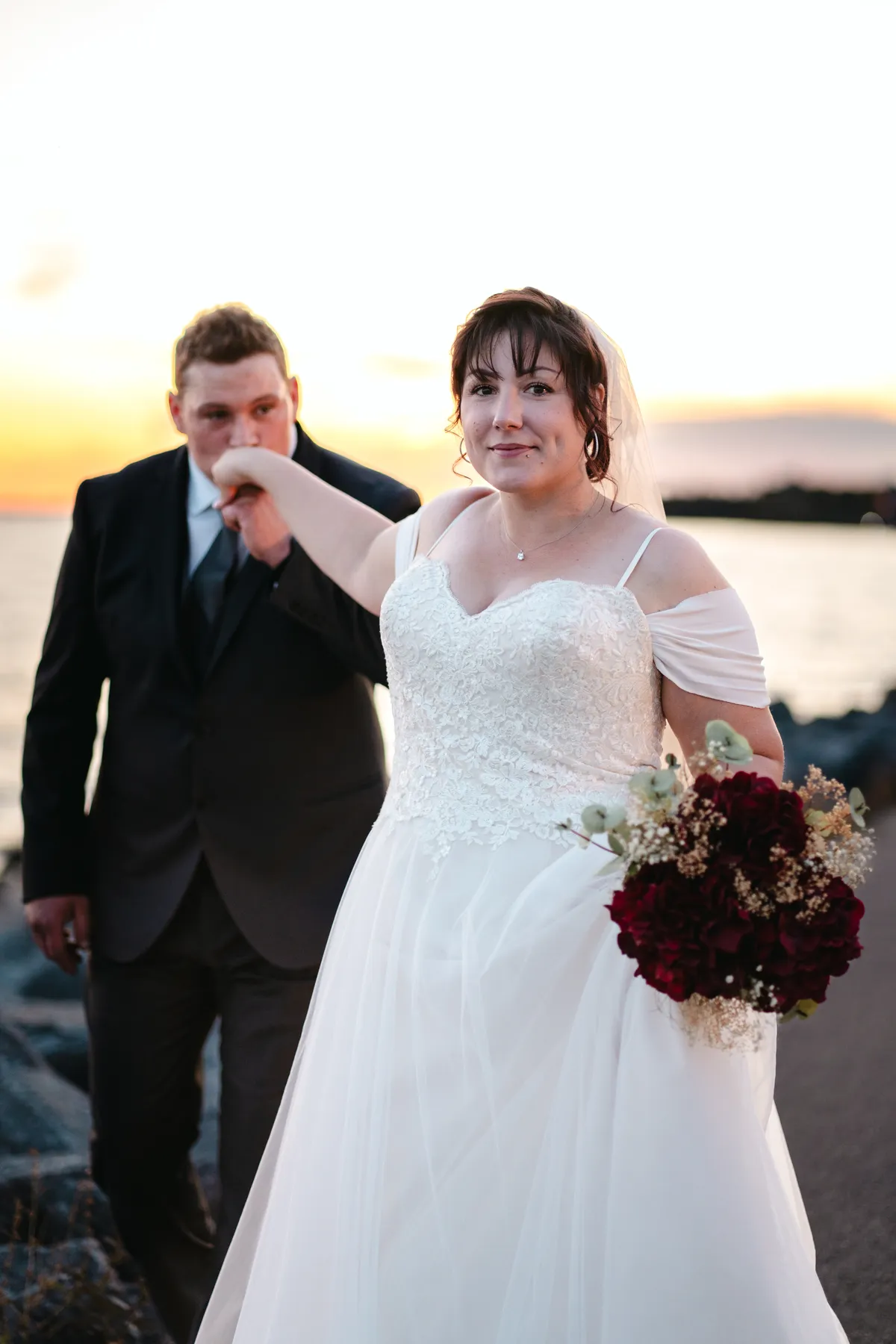 The couple posing by the water at sunset at Kody and Jaz’s wedding.