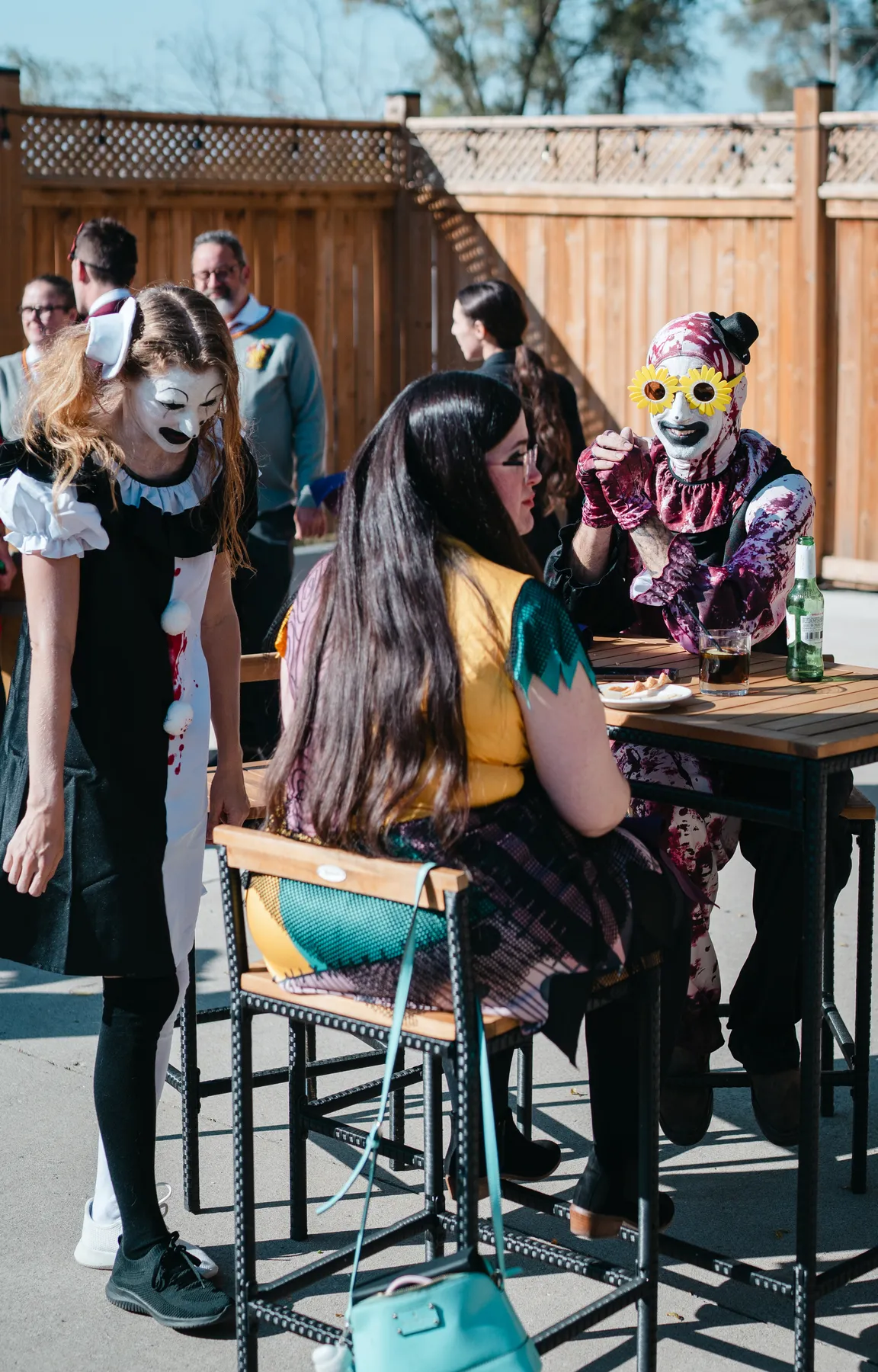 Costumed guests chatting in the outdoor courtyard at Jenna and Jake’s Halloween party.