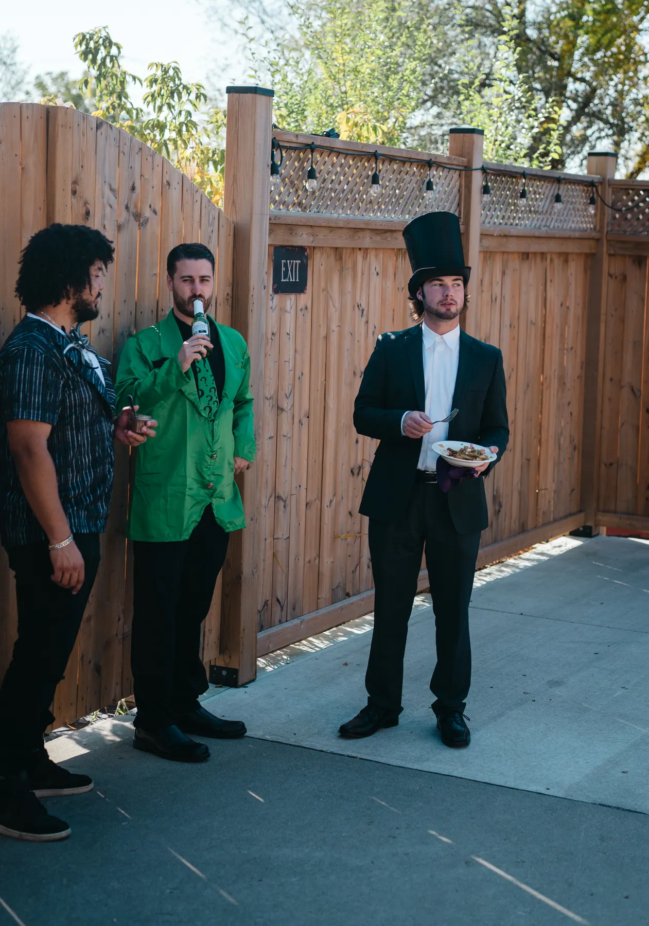 Costumed guests chatting in the outdoor courtyard at Jenna and Jake’s Halloween party.