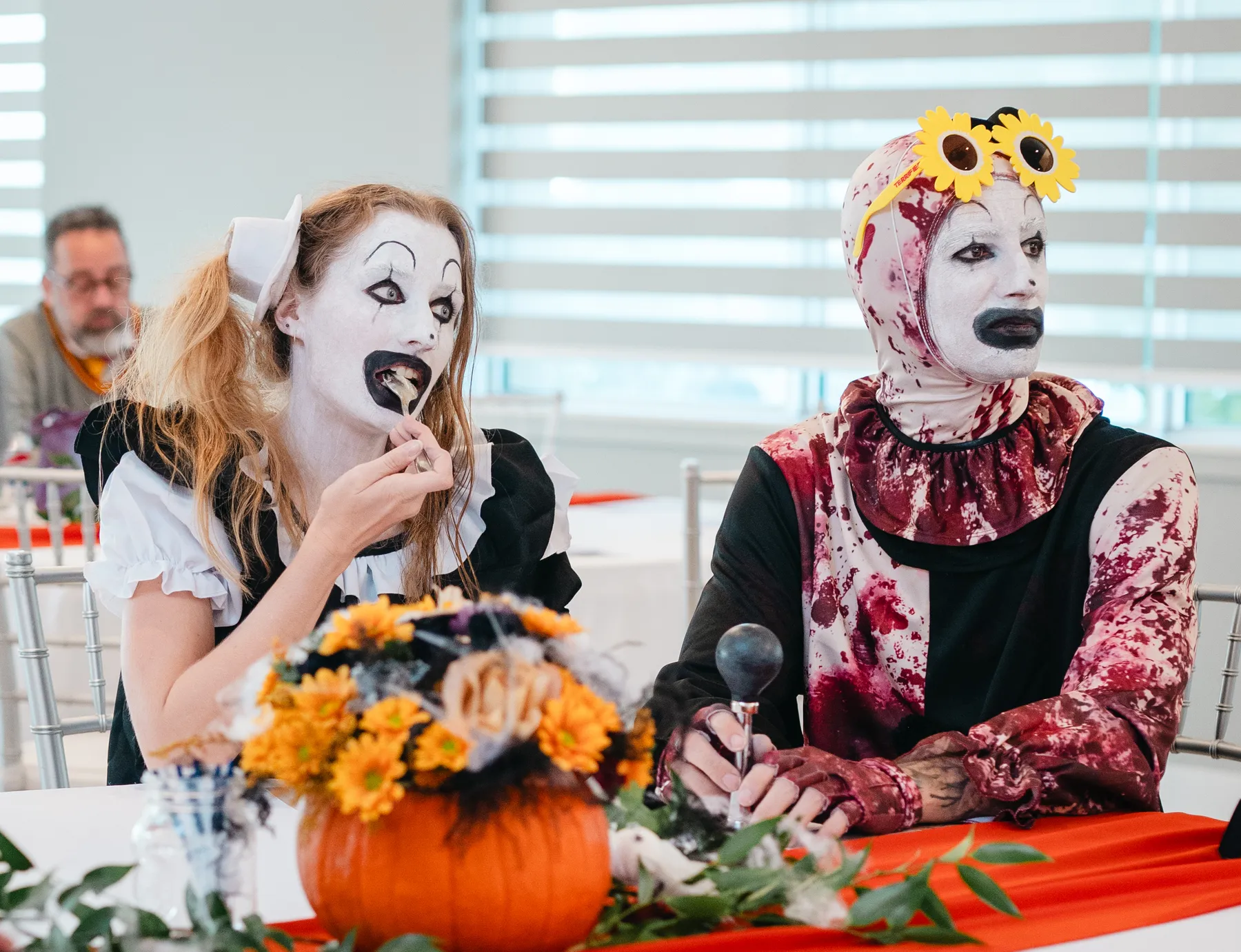 Costumed guests seated at a decorated table at Jenna and Jake’s Halloween party.