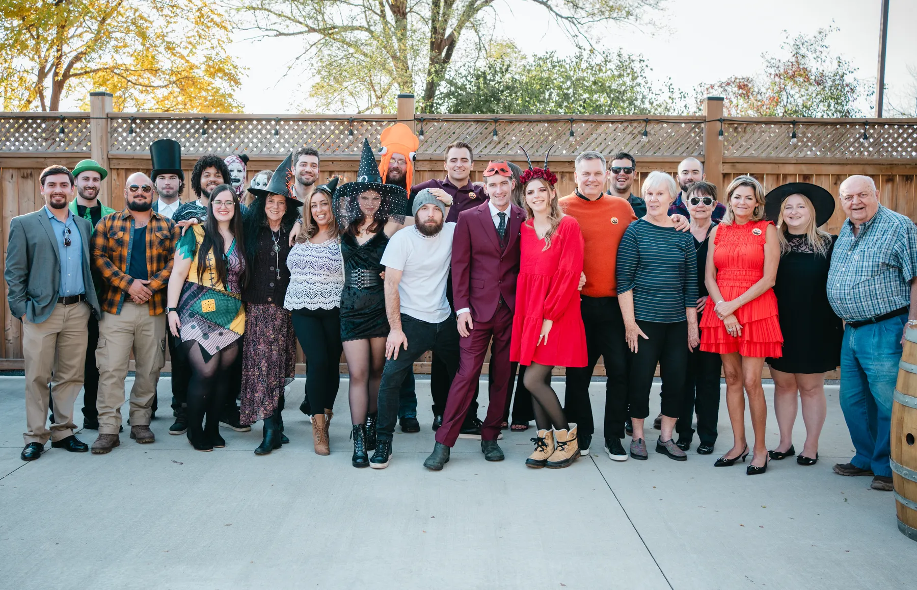 A large group of Halloween party guests posing outdoors at Jenna and Jake’s Halloween party.