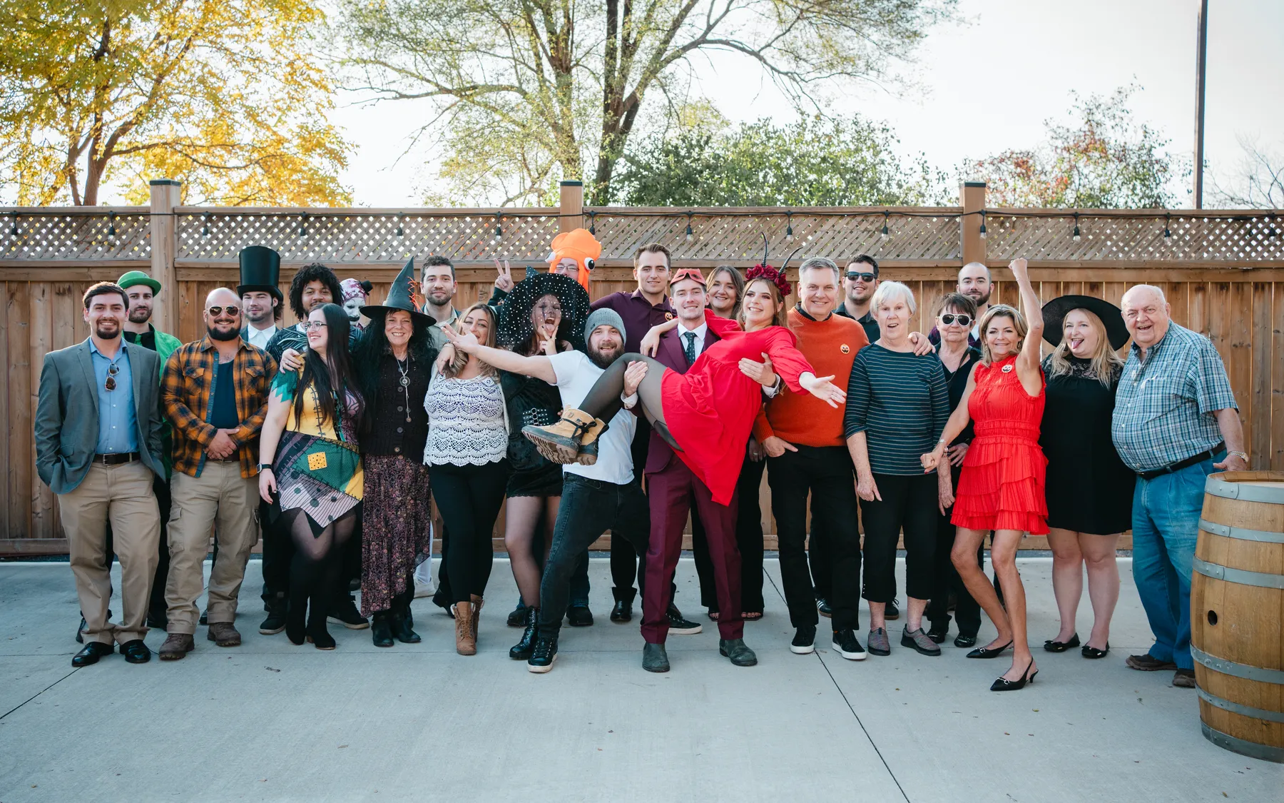 A large group of Halloween party guests posing outdoors at Jenna and Jake’s Halloween party.