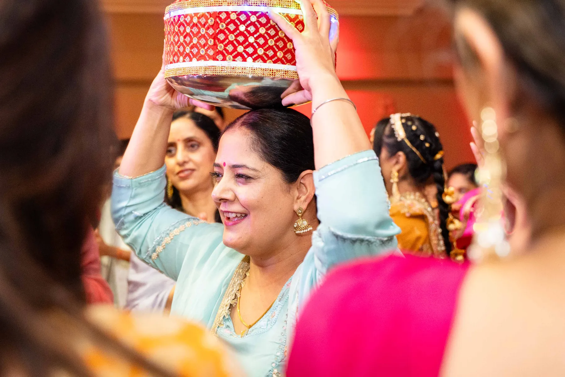 Guests dancing with decorated vessels at Jessie and Erin’s Haldi celebration.
