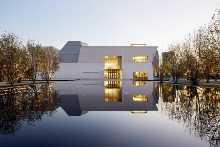Architectural view of the Aga Khan Museum surrounded by trees and calm water, popular among the wedding venues in the GTA.